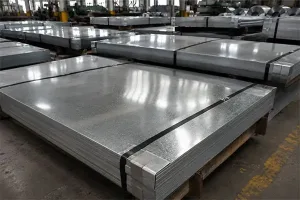 Stacks of shiny galvanized steel sheets with a protective zinc coating in an industrial warehouse setting, highlighting the difference between regular and treated steel.